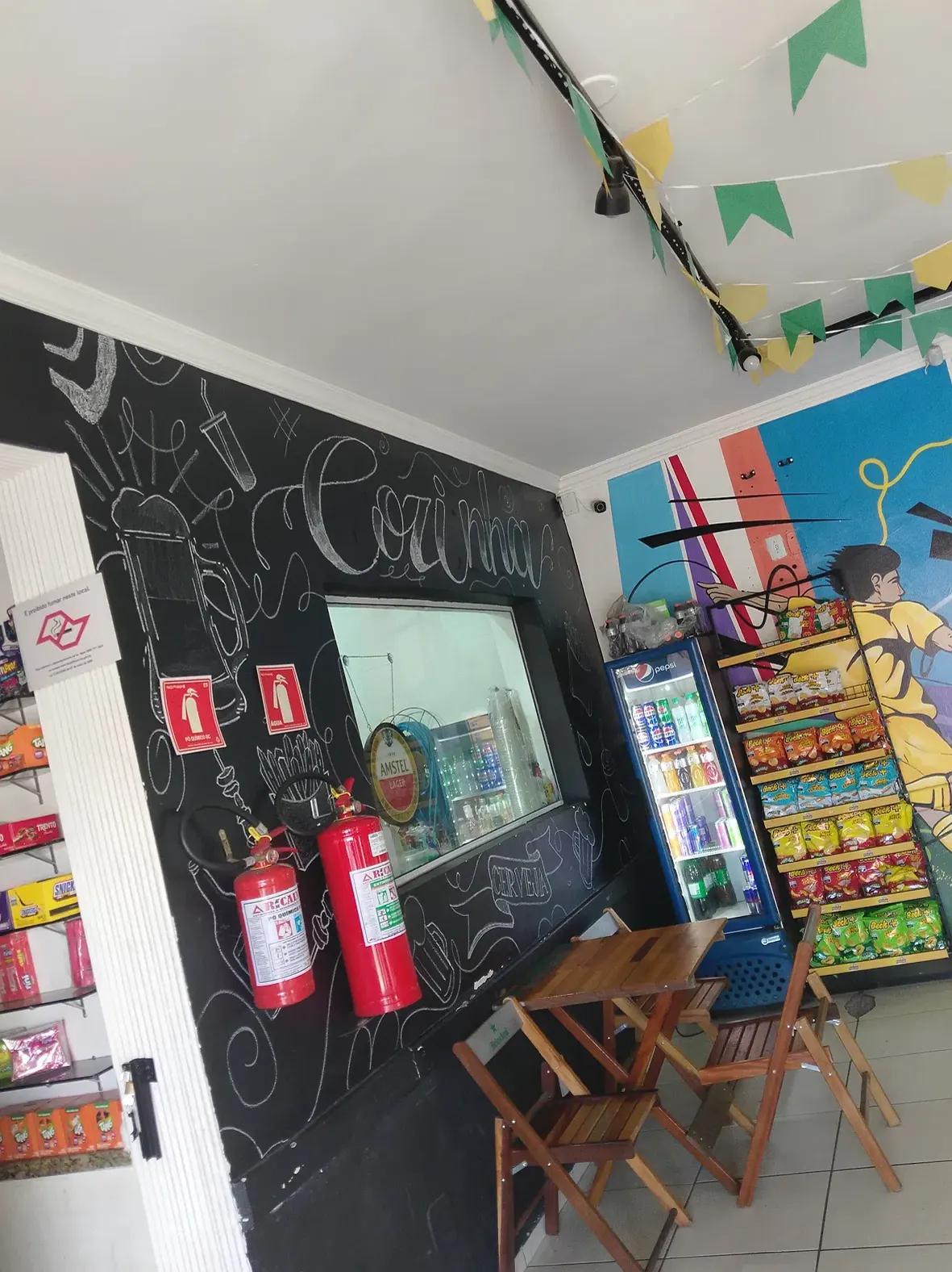 Área interna com mesas e freezer